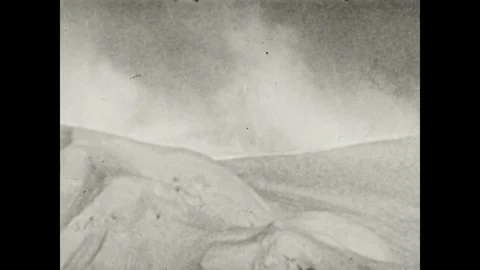 1940s: Wind blows snow on Mount Everest. Climber bends over. Stock Footage 116860259