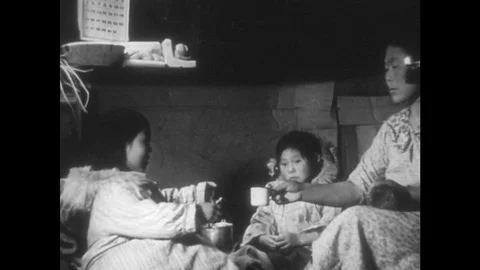 1940s: Woman hands cup to girl / Girl dips cup in water bucket / Close up, girl Stock Footage