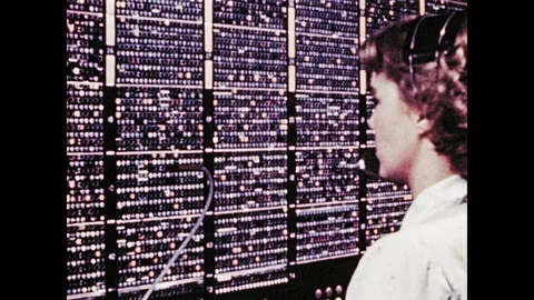 1940s: Woman speaks into headset and operates telephone switchboard. Puppet Stock Footage