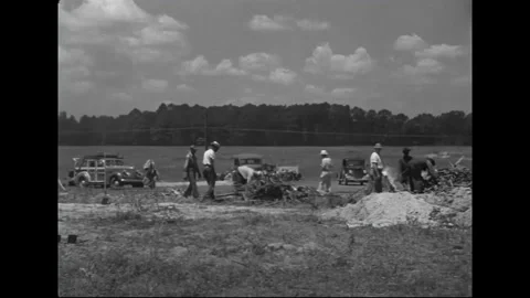1940s: Workers diligently stack wood and brush, while flames dance atop certain Stock Footage 157133941