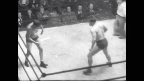 1940s: Wrestler head butts opponent repeatedly. Wrestler pins opponent and Stock Footage