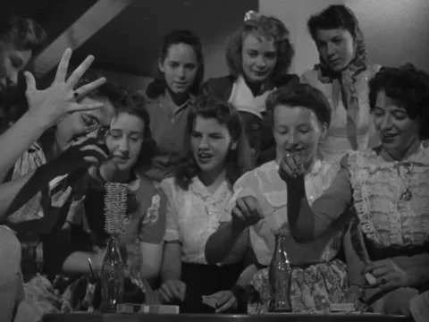 1940s: Young women stack toothpicks on soda bottles Stock Footage 231725352