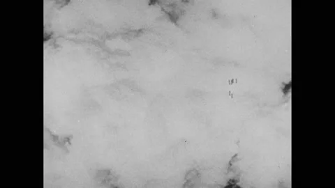 1940s:Bombs drop through clouds. Buildings on fire. Town in ruins after bombing. Stock Footage 232948343