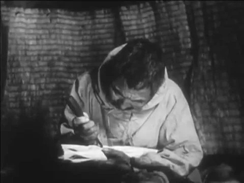 1941 _A man in an Eskimo family carves a walrus tusk, and women clean and dry Stock Footage