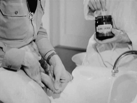 1941 - A soldier applies ointment to his penis and wraps it in paper in the Stock Footage
