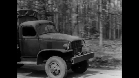 1941 - Soldiers demonstrate how to put on a gas mask while driving an army Stock Footage 88897666