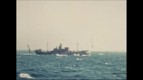 1942 - Troops load artillery on the deck of a warship traveling to Milne Bay in Stock Footage 83126148