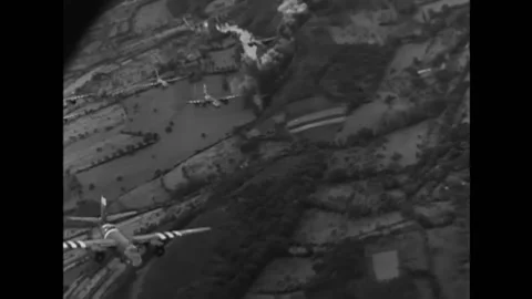 1943 - Bombs explode over France as B-26 bombers fly overhead, and ships line Video stock 232893638