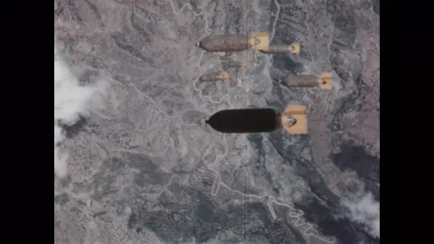 1943 - A camera in a B-24 bombers bay doors captures the view as bombs drop to Video stock 100860159