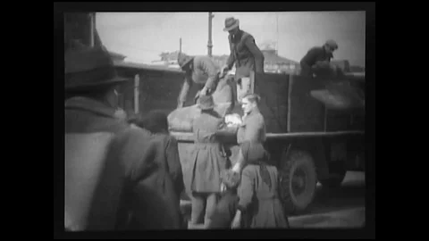 1944 - American MPs help get Italian refugees and their belongings onto trucks. Stock Footage 101700126