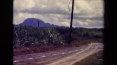1944: Dotted White Line Crosses Paler Curved Parallel Lines on Remote Road KAUAI Stock Footage 72396979