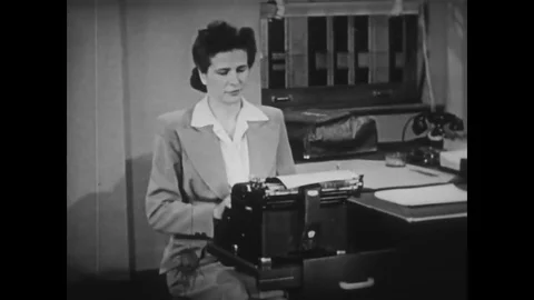 1944 - A secretary uses a protective cover and cleans the carriage rail in a Stock Footage