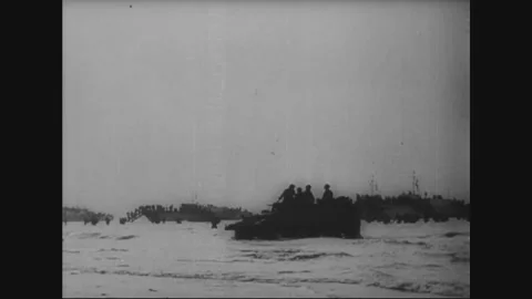 1944: Troops wade ashore past a beached landing ship Vidéo 338258634