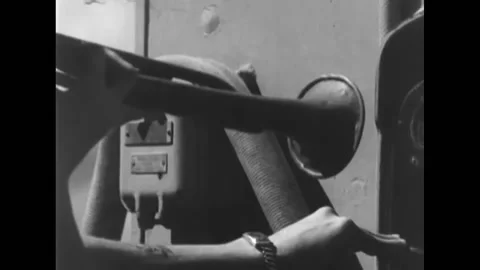 1945 - A bugler aboard warship plays into the PA system microphone. Gun crew Stock Footage 232892224