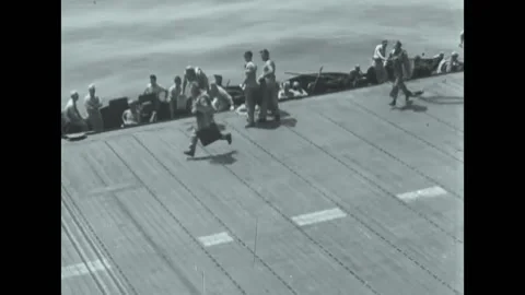 1945 - Men load bomb on a Hellcat plane which then takes off and joins a Stock Footage 220270278