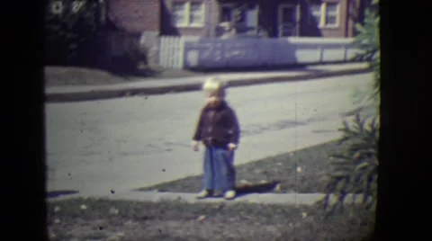 1946: Small Boy Standing on Roadside, Follows Lady in Detroit, Michigan 動画素材 68076002
