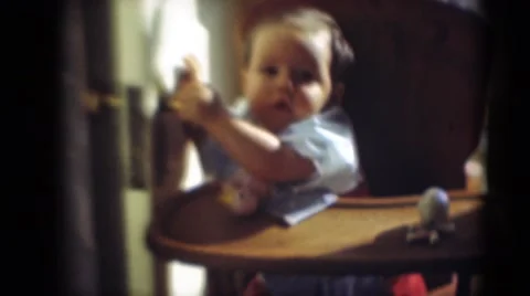 1947: baby in highchair grabbing door MIDDLETOWN Stock Footage