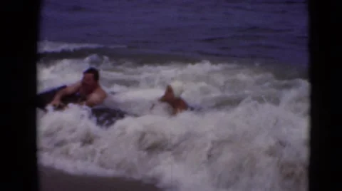 1947: couple catches waves on beach as they play and have fun. MIDDLETOWN Stock Footage