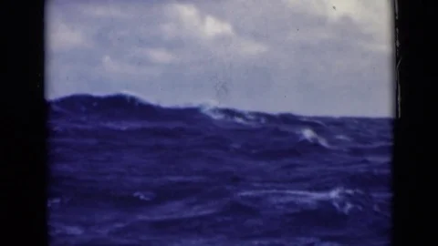 1947: Large White-Crested Waves in Ocean Crash and Swirl Against Cloudy Sky Stock Footage 72388873