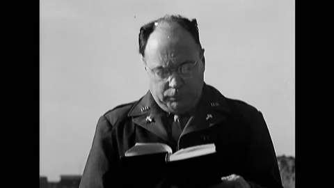 1948 - A US Army chaplain reads from the scriptures at a burial ceremony for Stock Footage 232892656