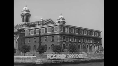1948 - View from a ferry sailing past the detention building on Ellis Island in Vídeos de archivo 205601328
