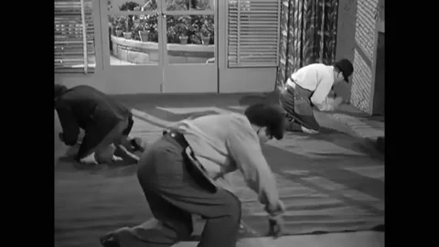 1949 - In this comedy, two carpet layers are hammering a carpet to the ground Stock Footage 241670037
