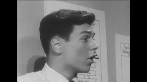 1949 -- A male student delegates tasks to a group. Video stock 115440243