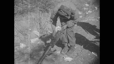 1950 - A US Army chaplain checks the bodies of dead American soldiers in a ditch Stock Footage 226848091