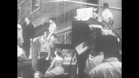 1950s: actors on set, camera and orchestra in TV studio. office building in Stock Footage 83642098