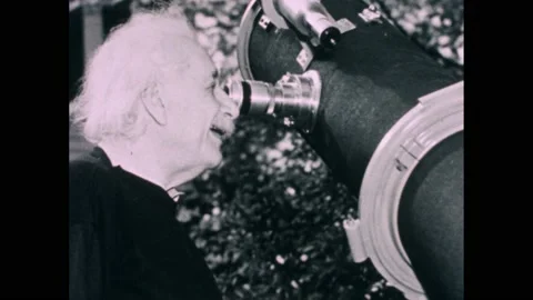 1950s: Albert Einstein looking in telescope, diagram of heat energy becoming Stock Footage 169182325