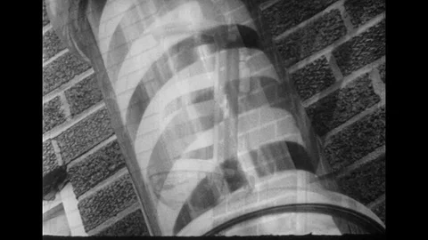 1950s: Barber pole / Close up of barber pole / Sign advertising haircuts / Man Stock Footage 74560979