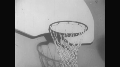 1950s: Basketball misses basket. Teenage boy in gym clothes dribbles ball, Stock Footage