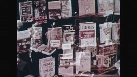 1950s: Book store window display. Several books on stand. Male student sits Stock Footage 77740062
