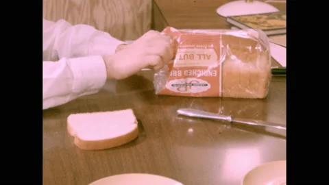 1950s: Boy cuts slice of white bread in half. Boy places slices of bread on 스톡 동영상 140122385