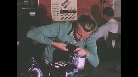 1950s: Boy fixing toaster, pan to boy fixing radio / Teacher watches boy chisel Video stock 75038452