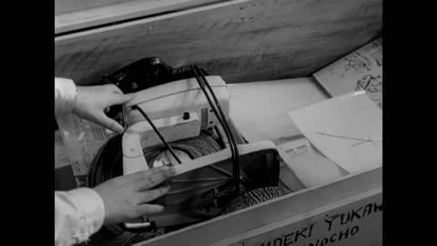1950s: Boy loads a stand mixer in a trunk. Cyclotron equipment. Lighted signs Stock Footage