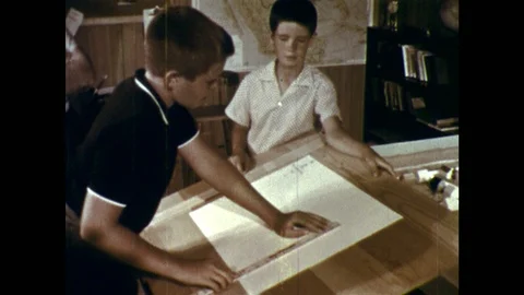 1950s: Boy measures paper on drafting table. Hands write scale dimensions on Stock-Footage 118146046