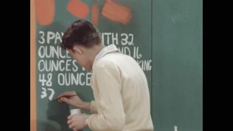 1950s: boy paints math problem about ounces on wall, dips brush in jar of paint Stock Footage 172031049