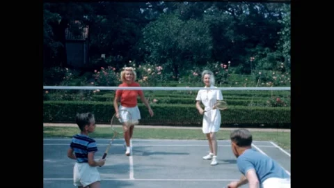 1950s: Boy returns a shots on a badminton court. Man, boy and women play. Boy Stock Footage 164317911