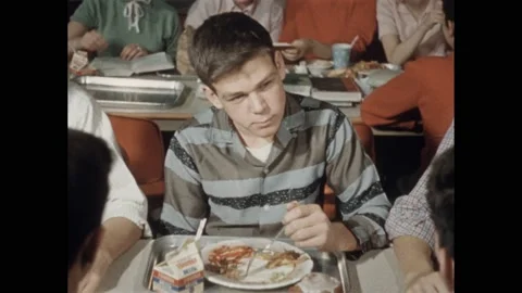 1950s: Boy talks and eats lunch in school cafeteria. Telephone operator flips Stock Footage 239166692