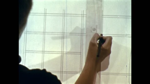 1950s: Boy uses ruler to draw grid on paper. Boy drafts map of neighborhood Stock Footage 118146038