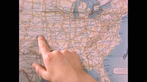 1950s: Boy's hand points to highways on map of the United States. Map of United Stock Footage 164542528
