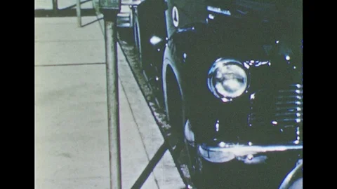 1950s: car parallel parked next to sidewalk, car pulling out of parallel parking Stock Footage 122302363