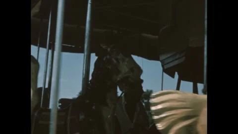 1950s: Carousel horses start to spin. Carousel. Man stands before a circus Stock-Footage 244481484