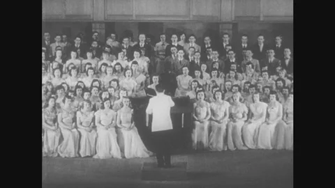 1950s: Choir sings. Conductor directs choir using baton. Stock Footage