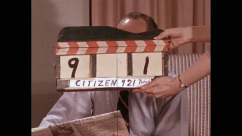 1950s: clapper board in front of actor’s face. Man smiles at camera. Citizenship Stock Footage 219965384