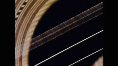 1950s: Close up, guitar string vibrating. Guitar string superimposed over Stock Footage 98333818