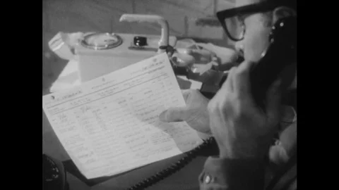 1950s: Close up of paper as man makes phone call. Man speaks on telephone. Stock Footage 75167212