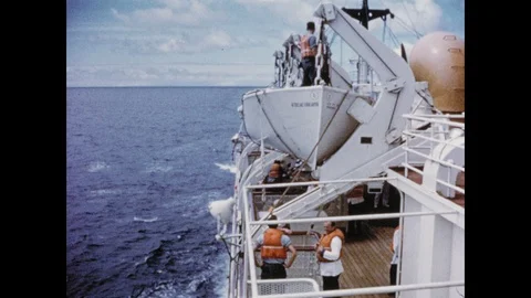 1950s: Crew members on a ship lower a lifeboat, preparing for potential Stock Footage 106762297