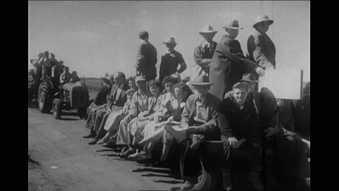1950s: Crowd by fence. Tractors pull people on floats. Man driving tractor. Men Stock Footage 167099093